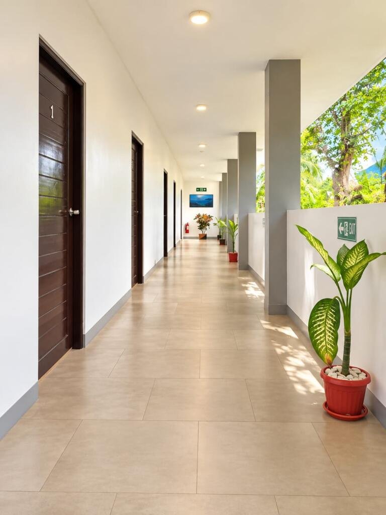 Open-air room corridor with tropical plants, Sunset Cove Beach Resort Romblon Philippines
