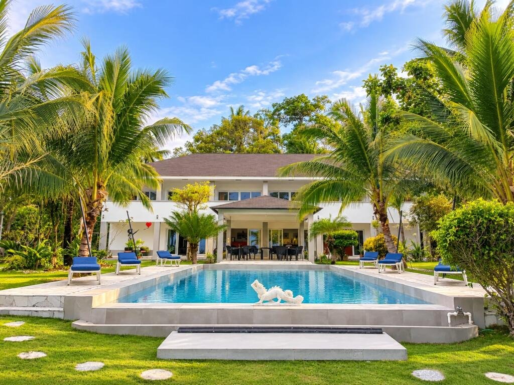 Swimming pool with white dragon fountain and palms at Sunset Cove Beach Resort, Romblon Philippines