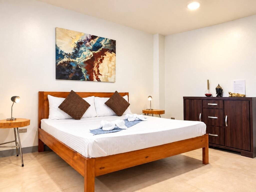 Suite Deluxe Seaview bedroom with king bed and hardwood dresser, Sunset Cove Romblon Philippines